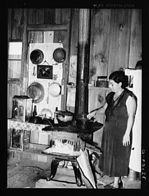 Wife of Mexican farm owner in kitchen. Hidalgo County, Texas