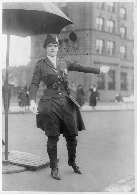 [Mrs. L.A. King, full, standing, directing traffic as...