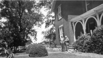 Unknown #25 - Two men in front of a house