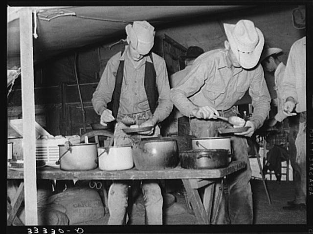 Cowboys of the SMS Ranch serving themselves at dinner at...