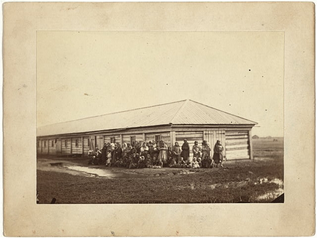 [Group of female exiles and their children standing in...
