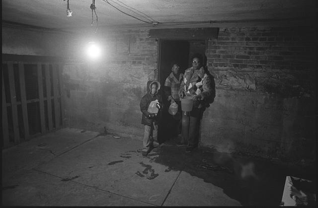 [Joyce Favell and her children in a basement? holding...