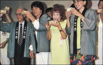 Kazuko Komori in a yellow dress with Jackie Chan, Raymond Chow and others