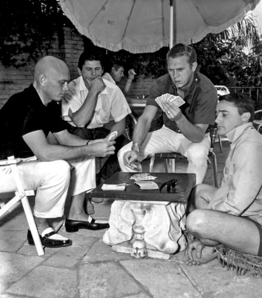 Yul Brynner, Charles Bronson, Steve McQueen and Robert Vaughn playing cards on the set of the film "The Magnificent Seven" 