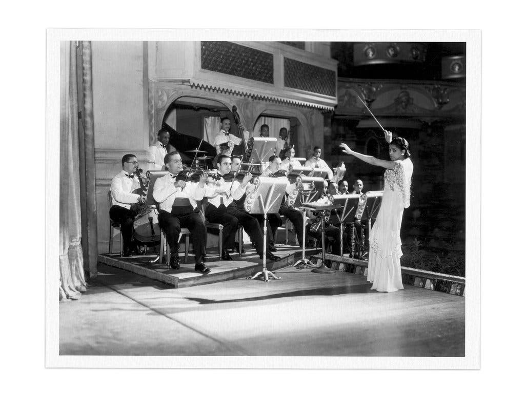 Conducting her own orchestra.