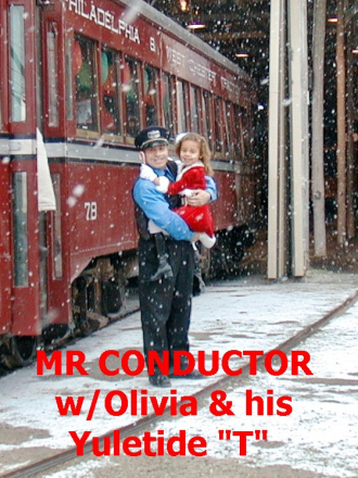 MR CONDUCTOR HOLDS LITTLE OLIVIA AT THE YULETIDE "T" SHUTTLE