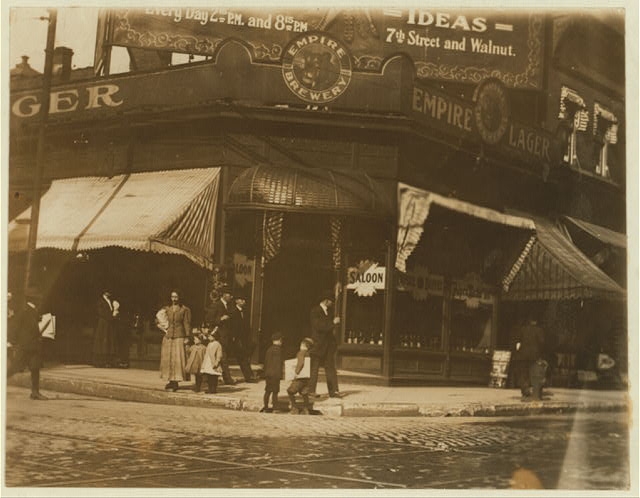 Newsies selling near saloon. Location: St. Louis, Missouri.