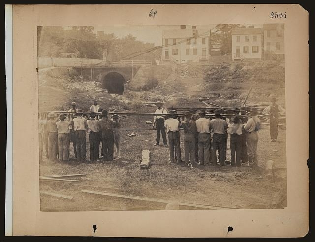 [Railroad construction workers holding track]