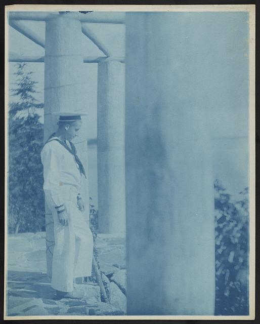 [Maynard White in sailor suit standing beside a column on...