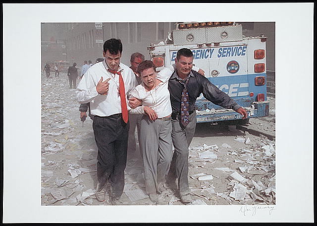 [Two men assisting and walking with an injured woman down...