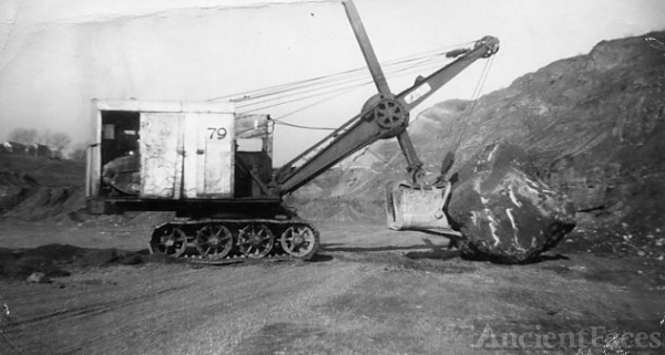 Clearing a boulder with a steam shovel