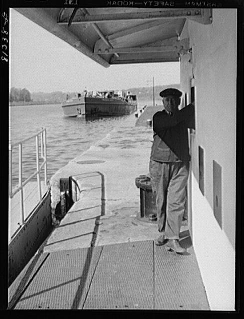 Lock hand opens lock gates by electric controls. Lock...
