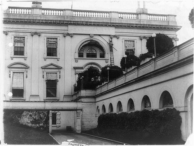 [Two workmen clearing cobwebs from exterior of the White...