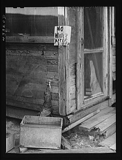 Sign at the only source of water in a trailer settlement...