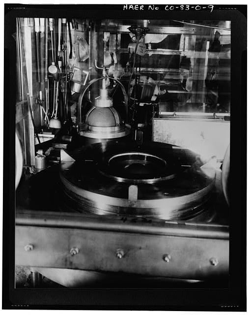 9. DETAILED VIEW OF BRIQUETTING PRESS HOUSED IN A GLOVE...