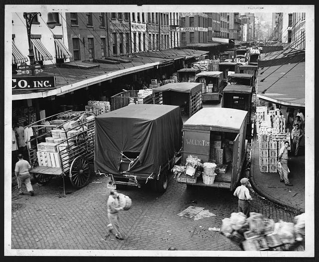 [Long lines of trucks being loaded with produce at...