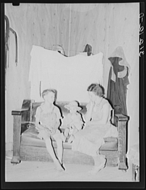 Sharecropper mother and children in corner of living...