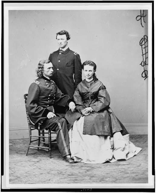 [George Armstrong Custer, in uniform, seated with his...