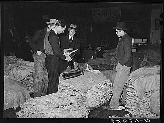 Salesman in tobacco warehouse selling shoes and boots to...