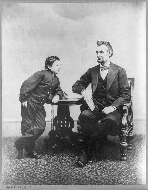 [Abraham Lincoln, seated and holding a book, with his son...