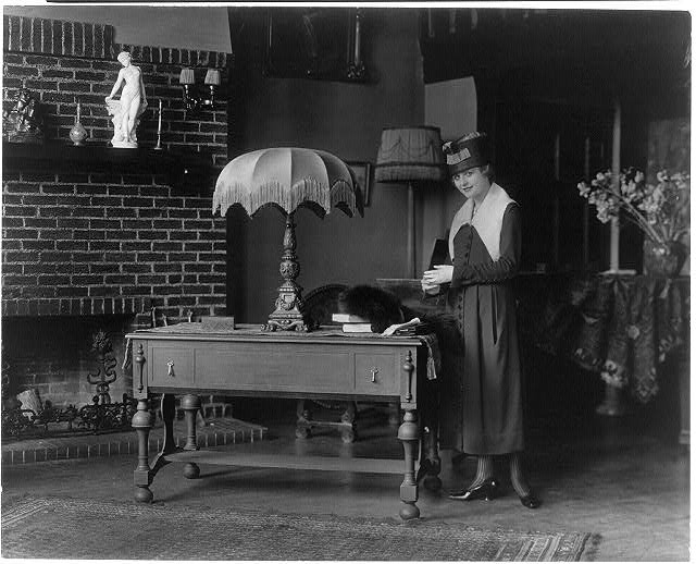Combination table and folding bed: woman standing...