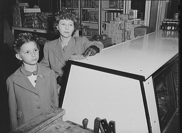 A patron and her daughter handling a ration book 