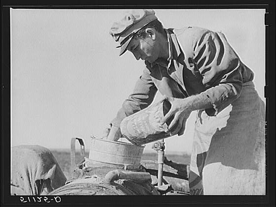 Migrant day laborer from Carolina mixing spray to kill...