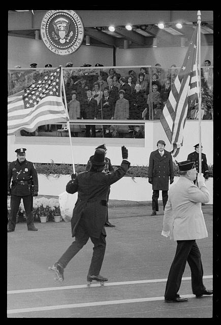 [Flag-waving, tuxedo-clad roller skater passes by...