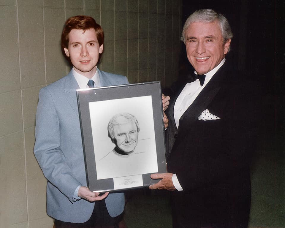 Steve Randisi presenting Merv Griffin with a portrait of himself.