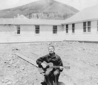 Haakon in the Army playing his guitar.
