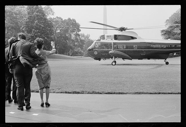 [Turning helicopter blades blow a strong wind on First...