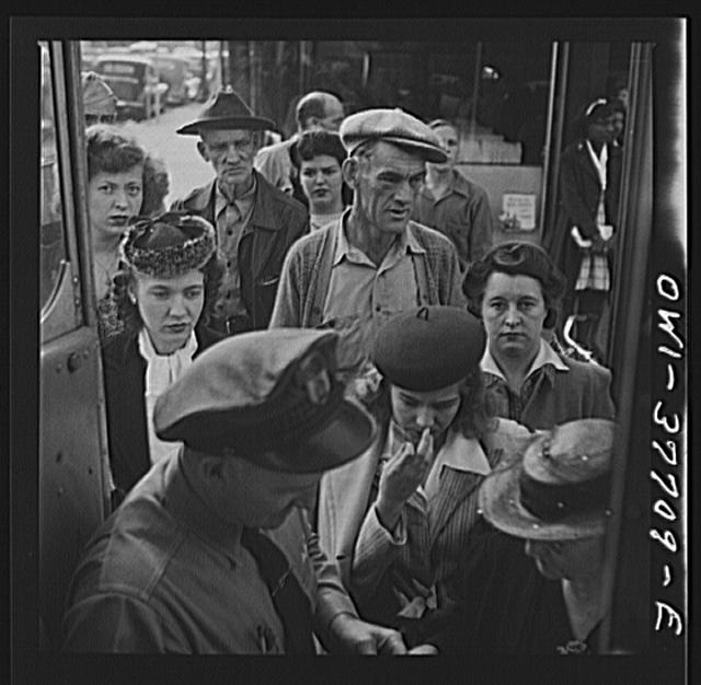 People boarding a Greyhound bus at a small town between...