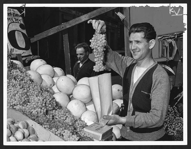 [Pushcart vendor Al Rabinowitz(?) bagging grapes at his...