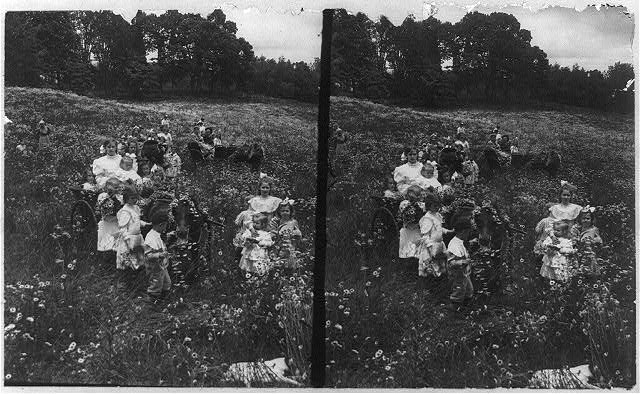 Group of children and several women in a field of...