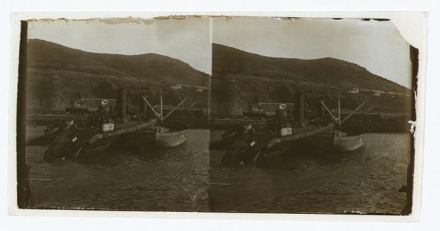 [A destroyed Russian warship being salvaged by a smaller...