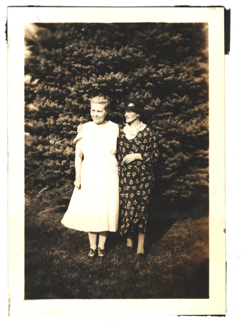 Two women in front of a tree