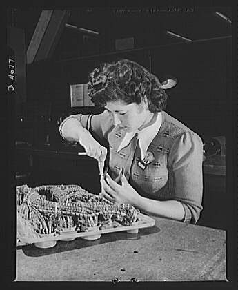 Women aircraft workers. An attractive brunette performs a...