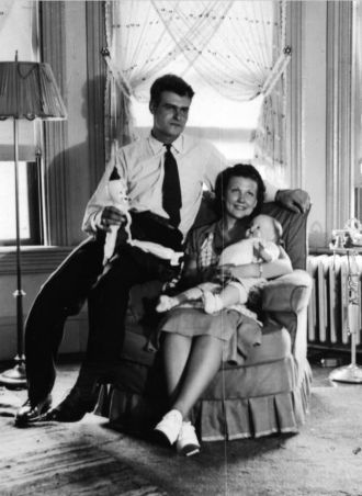 Man and Woman holding doll in chair