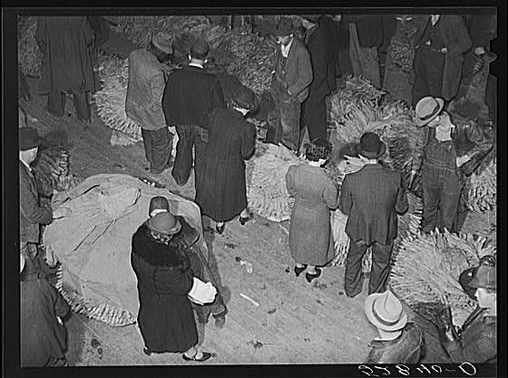 Farmers and their wives in warehouse during tobacco...