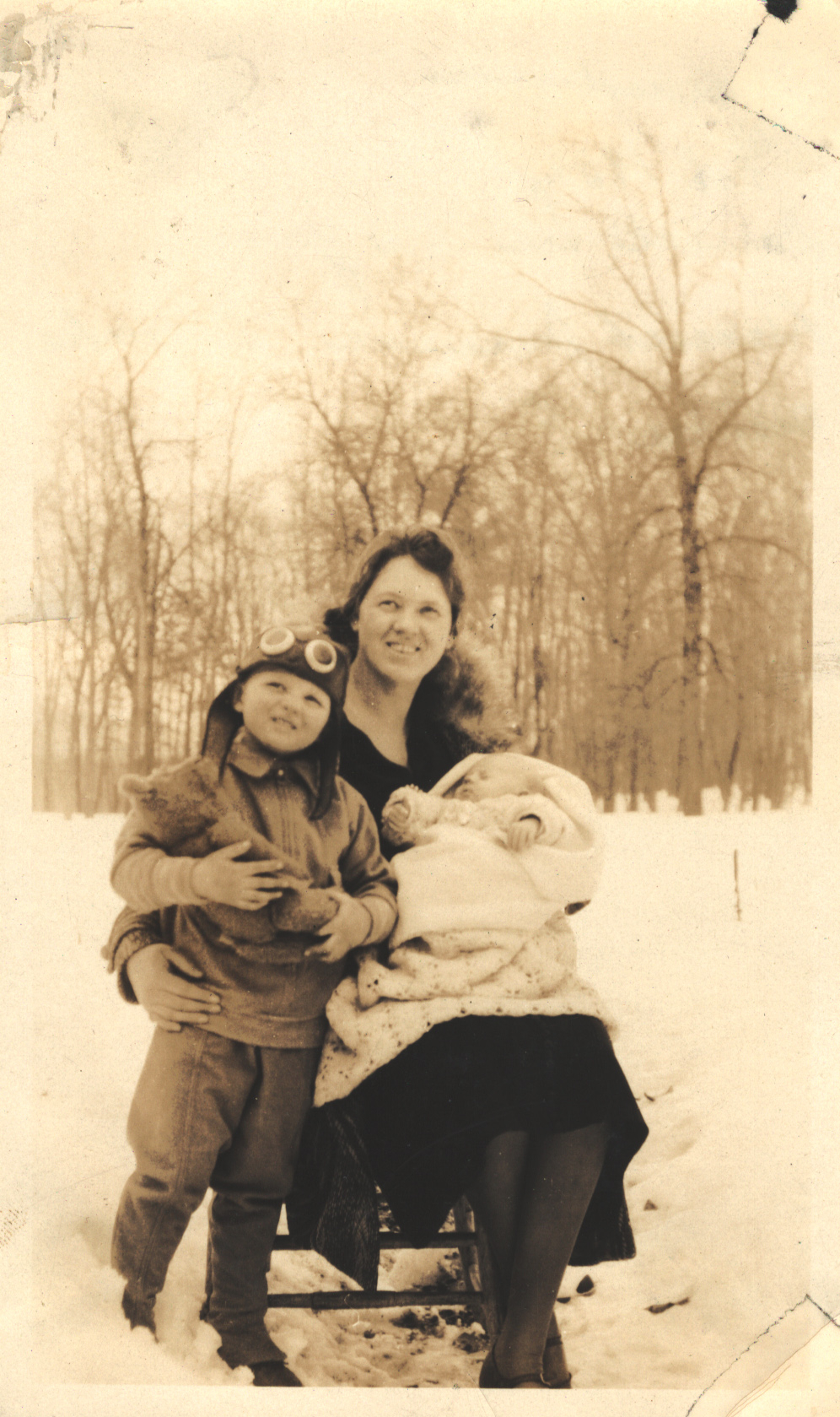 Woman in the snow with toddler and baby