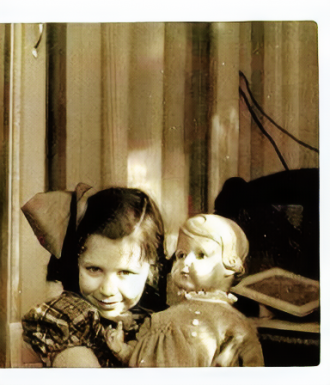 Just a little girl with a hair bow holding a doll