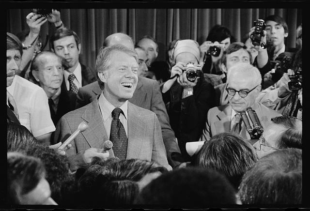 [President Jimmy Carter at a press conference, surrounded...