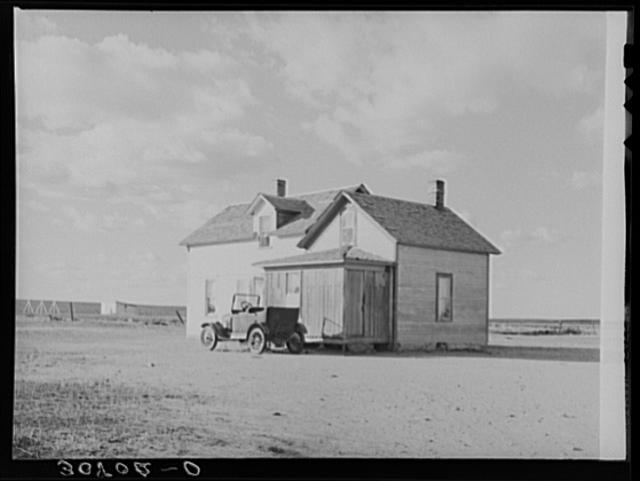 Farmhouse and old car. Williams County, North Dakota