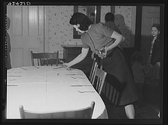 One of the daughters of Mr. T.L. Crouch setting the table...
