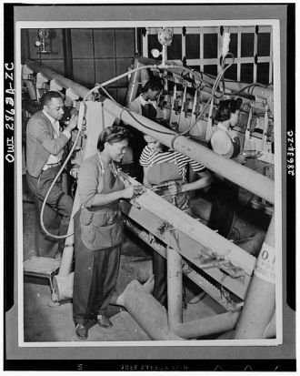 Negro men and women work side by side on the production...