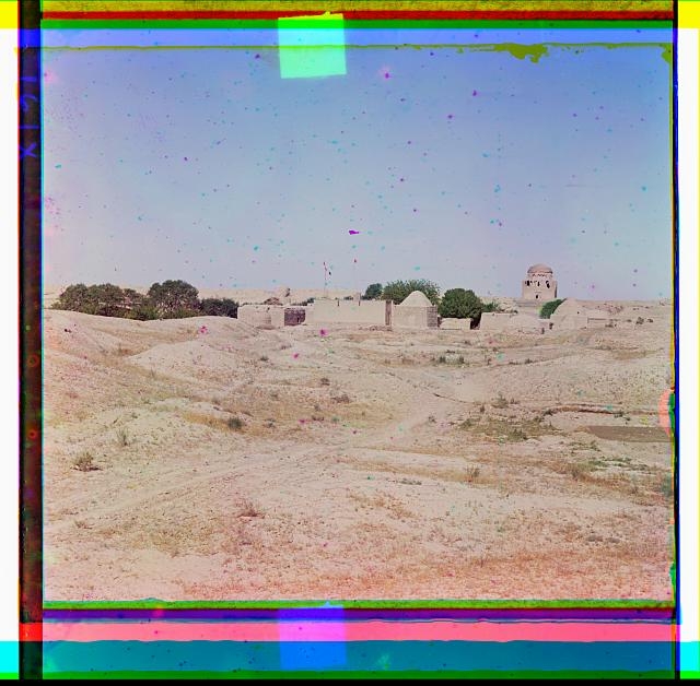 [Domed adobe buildings with crumbling mosque in background]
