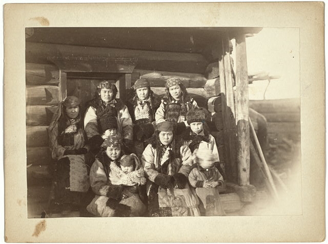 [Tatar women with children seated in front of their home]