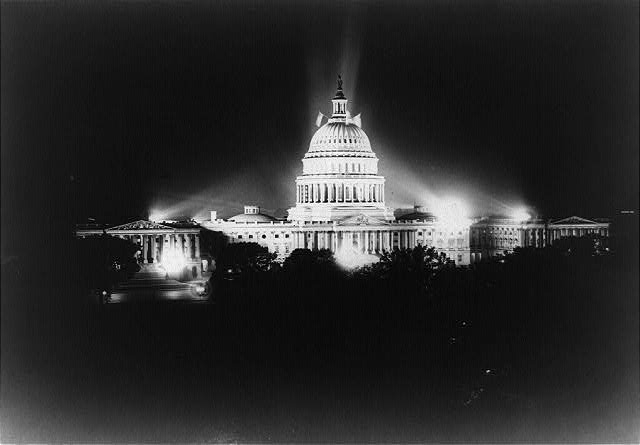 [Night view of the U.S. Capitol with lights shining on it]