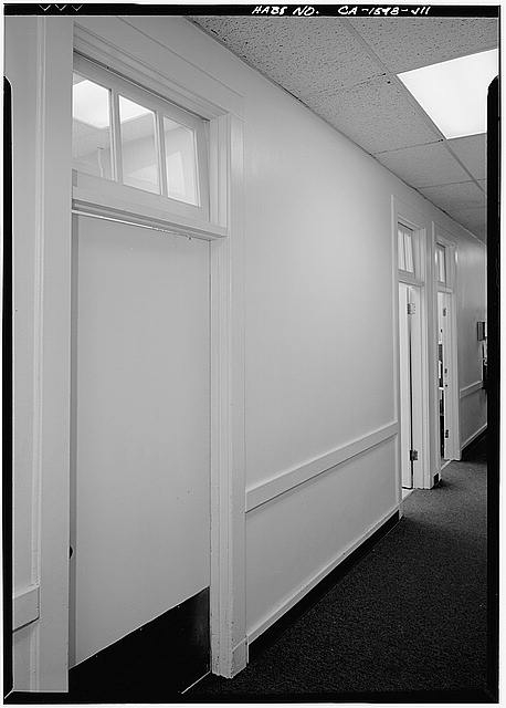 11. MAIN FIRST FLOOR CORRIDOR WITH UNPAINTED TRANSOM...