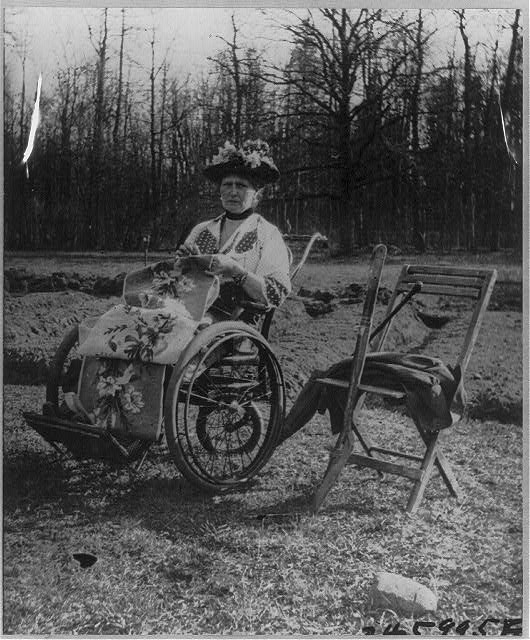 Empress Alexandra in her rolling chair embroiders while...